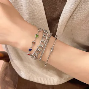 Nahaufnahme eines silbernen Armband-Sets mit bunten Herzperlen und minimalistischem Knoten-Reif