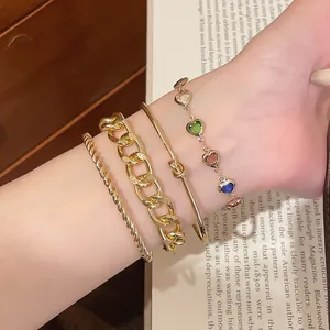 Nahaufnahme eines goldenen Armband-Sets mit bunten Herzperlen am Handgelenk