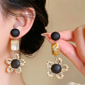 Boucles d'oreilles pendantes fleurs vintage avec clous noirs et élégants détails tissés
