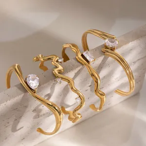 Stacked 18k gold plated stainless steel bangles with sparkling zircon accents on stone block