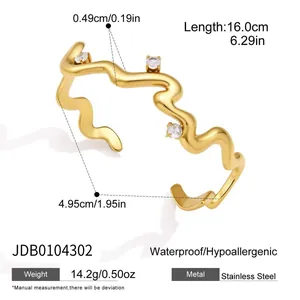 Detailed view of gold plated wavy stainless steel bracelet with cubic zirconia accents