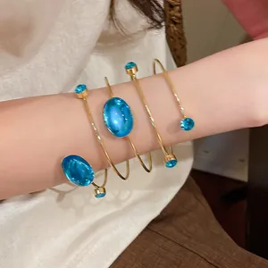 Détail d'un bracelet de bras bohème vintage avec des strass bleus sur spirale dorée