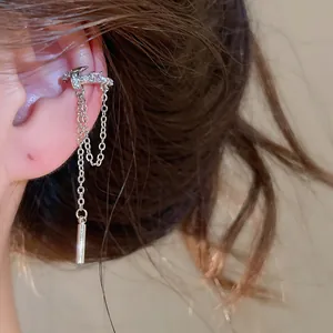 Detailansicht einer eleganten silbernen Stern-Ohrklemme mit Quastenkette am Ohr