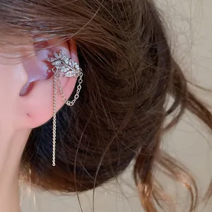Detailansicht einer eleganten silbernen Ohrmanschette mit funkelndem Blattdesign und Zirkon