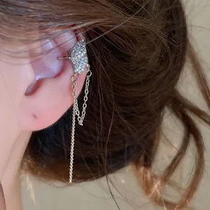Detailaufnahme eines silbernen Schmetterlings-Ohrclips mit funkelnden Quasten am Ohr.