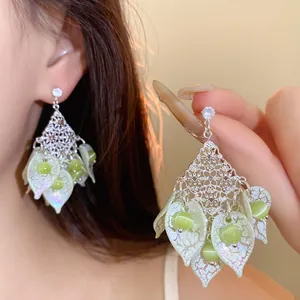 Detailansicht eleganter Silberohrringe mit Katzenaugenstein und grünen Blütenblättern