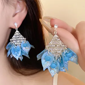 Detailansicht eleganter blauer Katzenaugenstein-Ohrringe mit feinen silbernen Filigranarbeiten.
