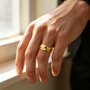 Vue détaillée d'une bague spirale dorée de 8 mm portée à la main près d'une fenêtre