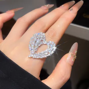 Macro view of a sparkling heart-shaped ring paved with cubic zirconia stones on a finger.
