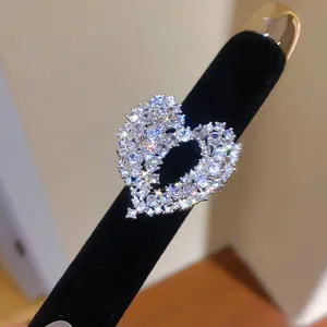 Close-up of a hollow heart ring with sparkling zircon stones on a black display stand