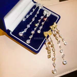 Elegante Schleifen-Ohrringe mit glitzernden Zirkonia in Silber- und Goldtönen.