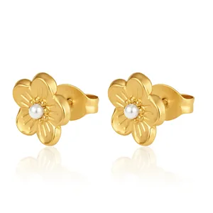 Nahaufnahme der goldenen Blumen-Ohrstecker mit einer Perle in der Mitte auf Weiß