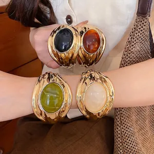 Vintage goldene Manschettenarmband mit großem ovalem Harzstein für elegante Damen