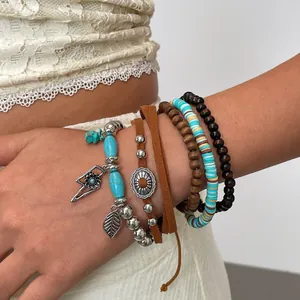 Detailopname van zes etnische boho-stijl armbanden met turkoois en houten kralen