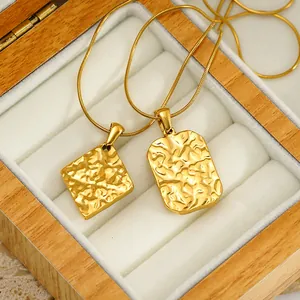 Close-up of vintage gold hammered texture square and rectangular pendants in a wooden box