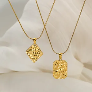Close-up of gold-plated stainless steel necklaces with hammered texture pendants