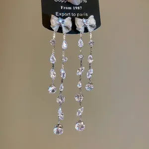 Detailansicht eleganter Schleifenohrringe aus Silber mit glitzernden Zirkon-Quasten
