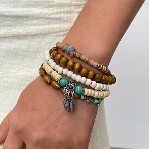 Gedetailleerde weergave van een zesdelige etnische kralenarmbandset met zilveren verenhangers