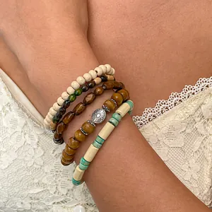 Close-up van bohemian houten en hars kralen armbanden set aan een vrouwelijke pols