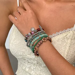 Detailopname van 6-delige bohemian kralenarmbanden met metalen veer- en zonvormige bedels