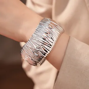 Detailansicht eines stilvollen silbernen Manschettenarmbands mit Faltenstruktur