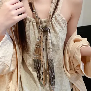 Gedetailleerde weergave van een vintage geplooide stropdas-ketting met sierparel