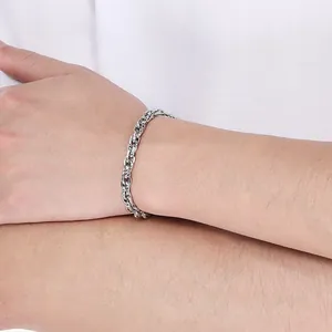 Detailansicht eines silbernen Edelstahl-Kordelkettenarmbands am Handgelenk eines Mannes.
