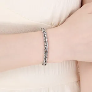 Nahaufnahme eines silbernen Edelstahl-Kordelketten-Armbands am Handgelenk