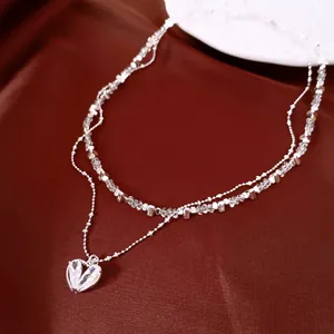 Détail du collier double rang avec pendentif cœur en oxyde de zirconium.