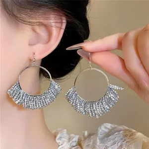 Detailansicht der glitzernden mehrlagigen Strass-Creolen mit Fransen in Silberoptik