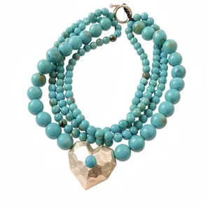 Meerlaagse turquoise kralenketting met grote gouden hartvormige hanger en OT-sluiting