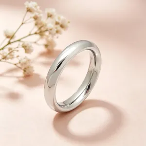 Macro view of polished 4mm stainless steel plain band ring with soft floral background