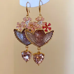 Detailansicht von Vintage-Ohrringen mit Harzengel und rosa herzförmigem Kristall