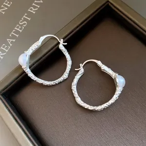 Nahaufnahme der Vintage-Silberohrringe mit Textur und elegantem Perlendetail