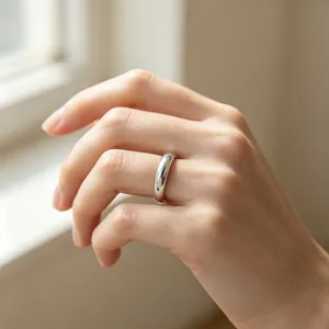 Close-up of 4mm smooth stainless steel band ring on model's finger