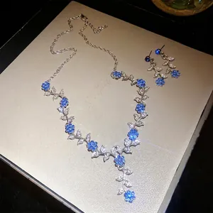 Glinsterende blauwe bloem en zilveren blad ketting en oorbellen sieraden set