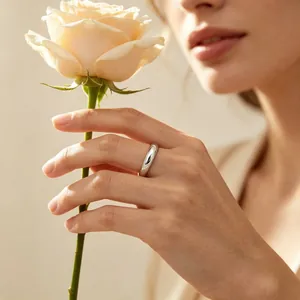 Close-up of a 4mm stainless steel smooth plain band ring worn on a finger