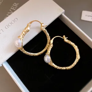 Detailansicht goldfarbener Retro-Hoops mit Hammerschlag-Textur und edler Perle