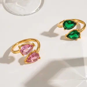 Detail view of gold-plated stainless steel rings with pink and green teardrop zircons.
