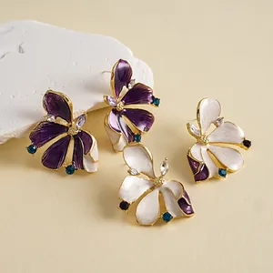 Detail view of elegant purple and white enamel flower earrings with colorful crystal accents