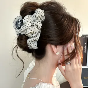 Détail d'une pince à cheveux en tulle à fleurs portée dans un chignon élégant.