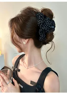 Vue détaillée d'une pince à cheveux en tissu floral noir pour un chignon élégant
