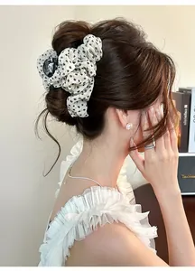 Gros plan d'une élégante pince à cheveux en tulle fleuri portée par un mannequin.