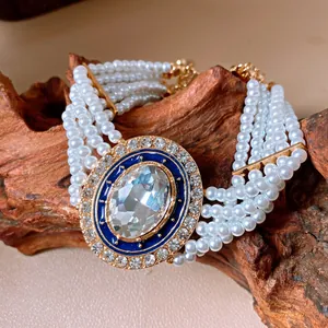Nahaufnahme eines mehrlagigen Vintage-Perlenarmbands mit ovalem Strass und Emaille-Detail.