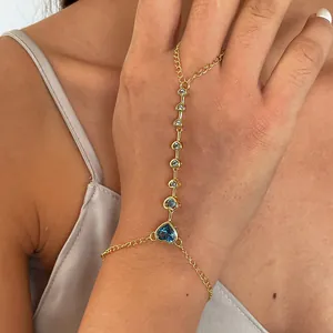 Gedetailleerde close-up van een 18k vergulde hart handketting met blauwe zirkoniasteen.