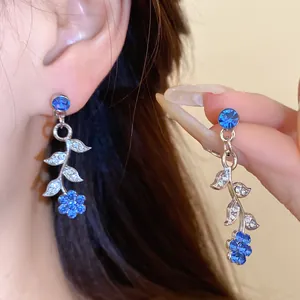 Close-up van elegante blad- en bloemoorbellen met sprankelende blauwe strass-steentjes