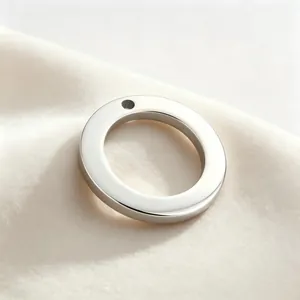 Close-up of a minimalist glossy stainless steel ring pendant with single hole for DIY