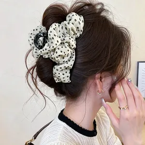 Elegant vintage floral fabric hair claw clip shown in a stylish messy bun hairstyle