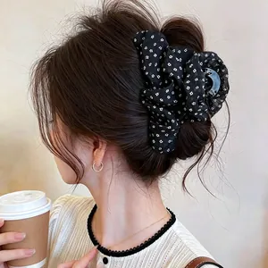 Close-up of a Korean style fabric floral hair claw clip on a bun
