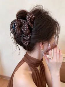 Detailed view of a brown floral fabric hair accessory styled in a chic and elegant bun.